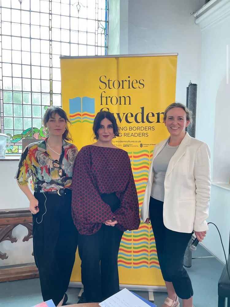 Saskia Vogel, Balsam Karam and Cristín Leach standing in front of a Stories from Sweden banner in Marino Church in Bantry, at the West Cork Literary Festival. 