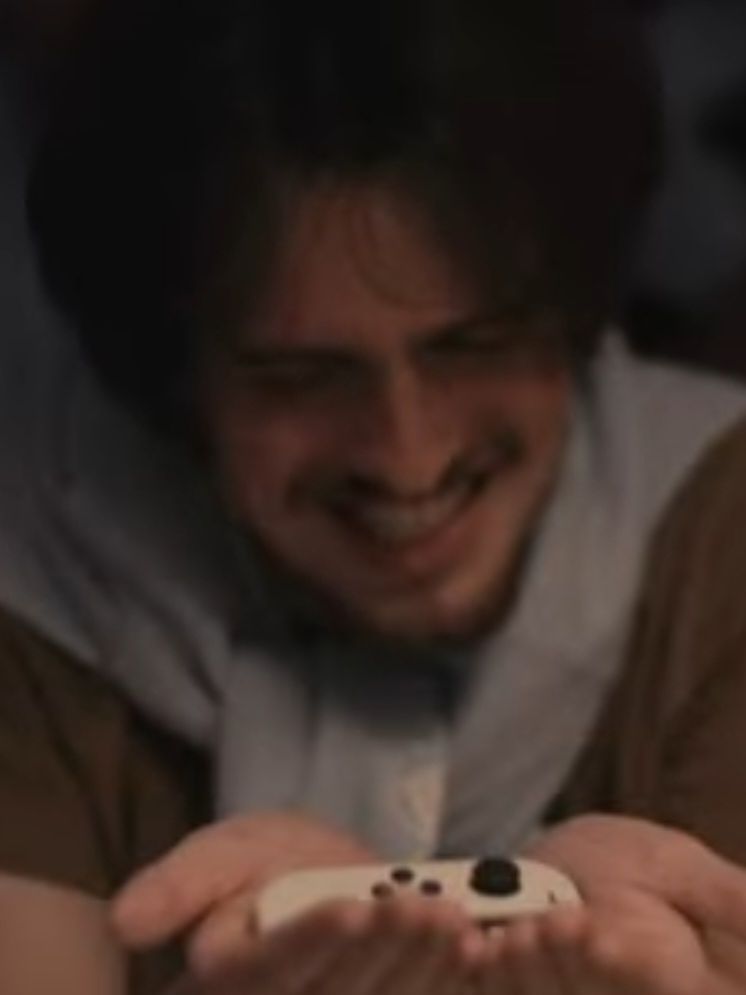 Jorge gently holding a white switch joycon in his hands