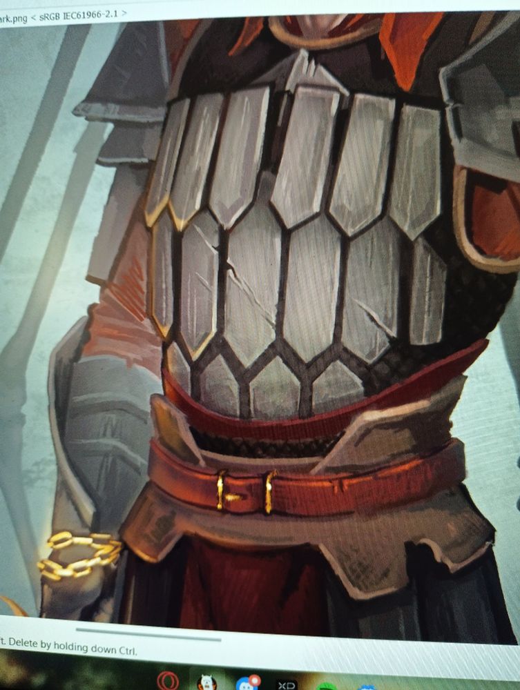 Armor closeup on my monitor, its got some fiery red cloth in there and the metal seems lightly damaged, almost like cracked