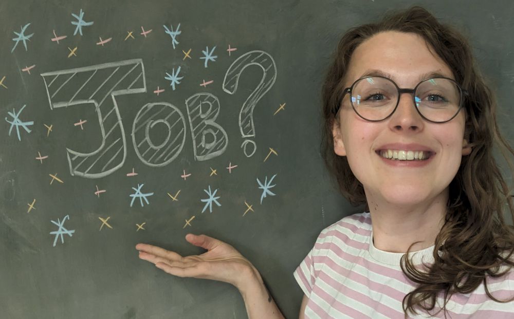 A selfie of me stood next to a blackboard. The word "Job?" is written next to me on the blackboard.