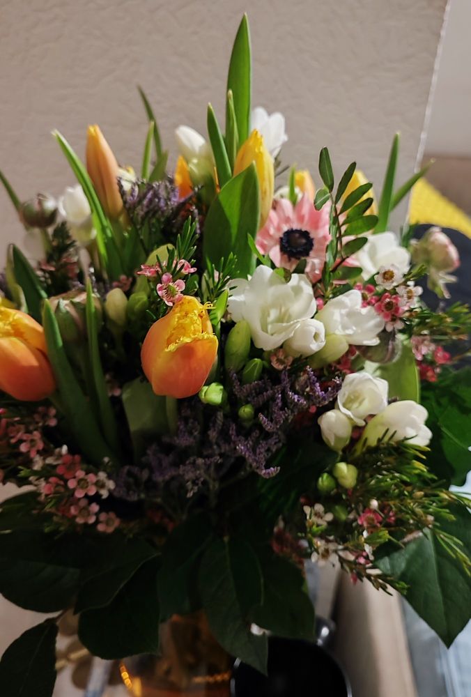 Ein bunter Blumenstrauß mit ein paar Tulpen, Freesien und allerlei anderen Blumen.