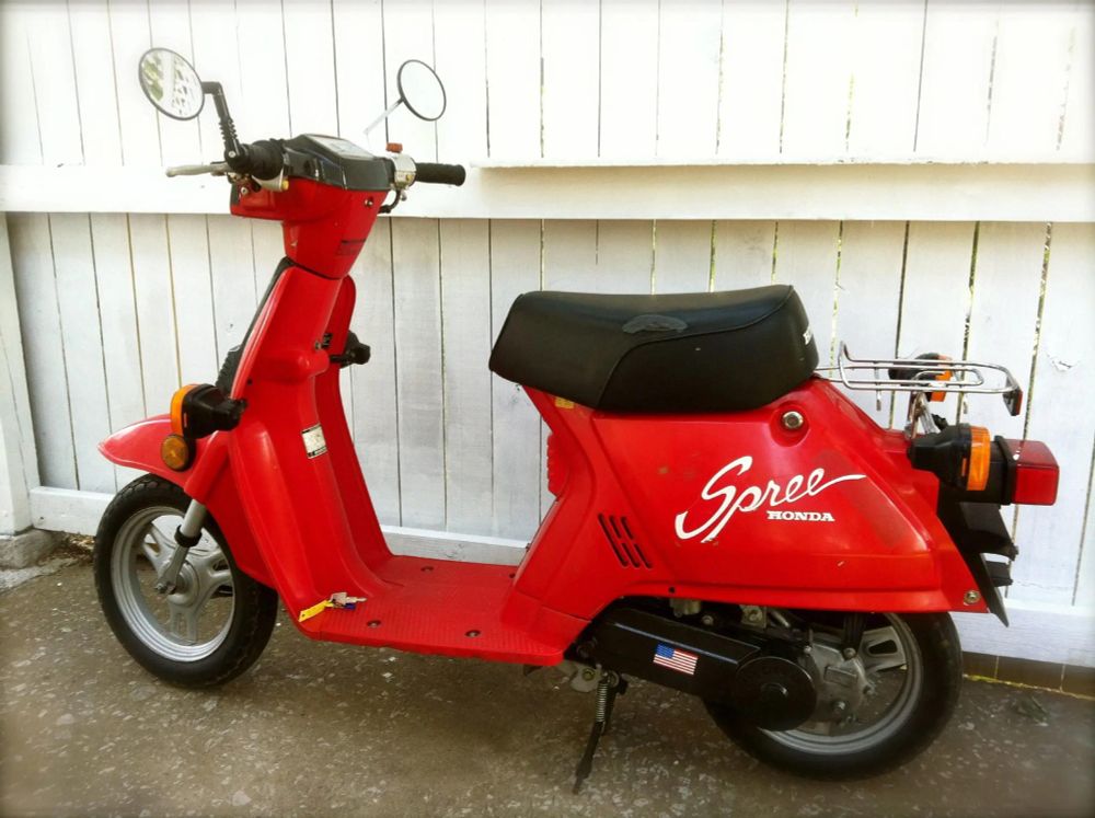 A cherry red Honda NQ50 49cc scooter, better known as the Spree, produced from 1984–87. It wasn’t as cool as the DEVO-endorsed Elite 150, but it was street legal without a motorcycle license.