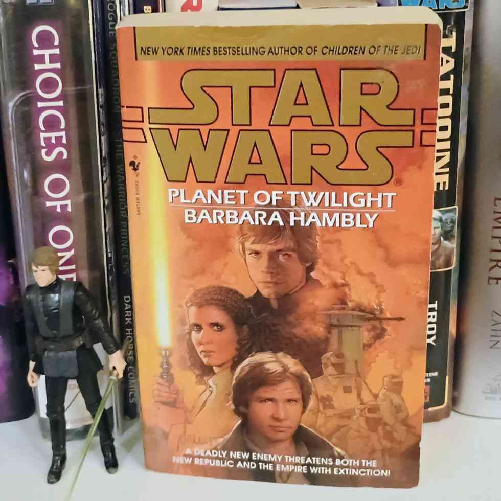 A picture of the novel Star Wars: Planet of Twilight" by Barbara Hambly sitting on a shelf of other Star Wars books