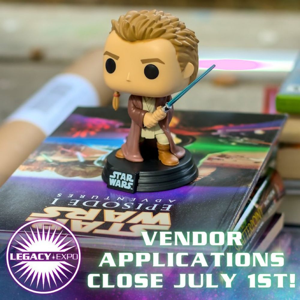An action figure bobblehead of Obi-Wan Kenobi sitting atop books.