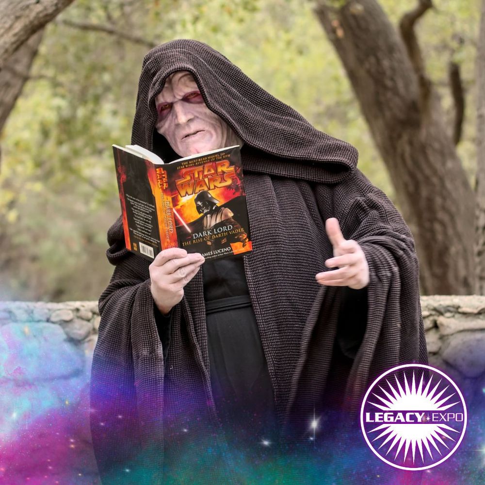 An Emperor Palpatine cosplayer reads a copy of  "Dark Lord: The Rise of Darth Vader" by James Luceno.