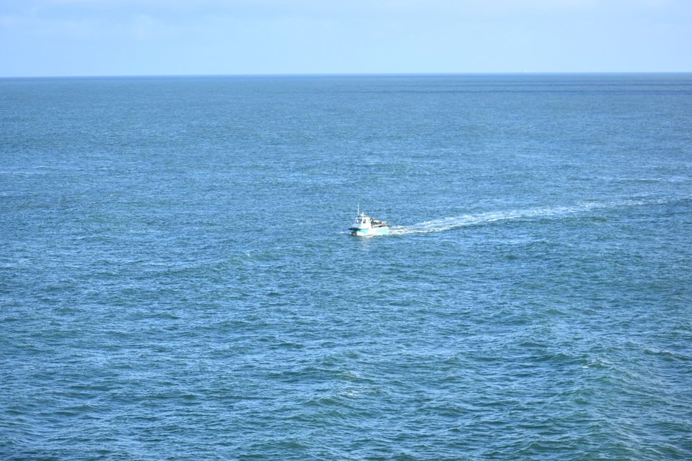Small fishing boat checking lobster pots in Bull bay Anglesey 