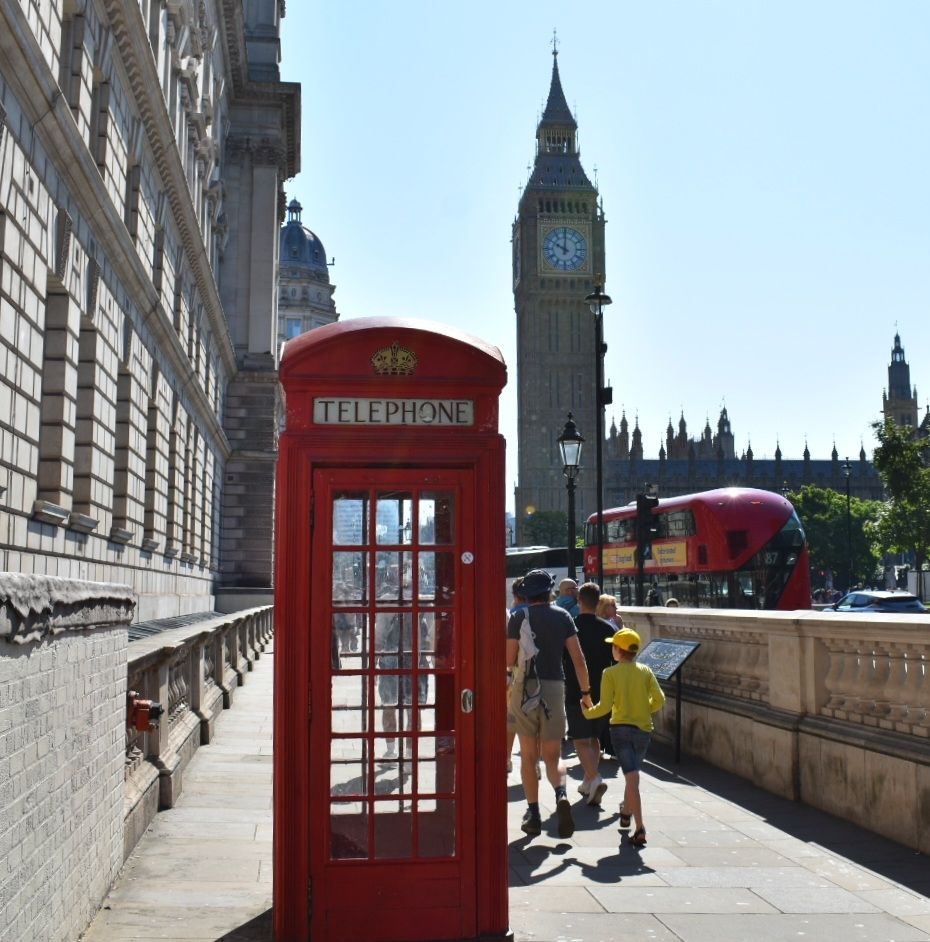 Classic London scene, red telephone box, red bus, tourists and Elizabeth Tower on the Palace of Westminster 
