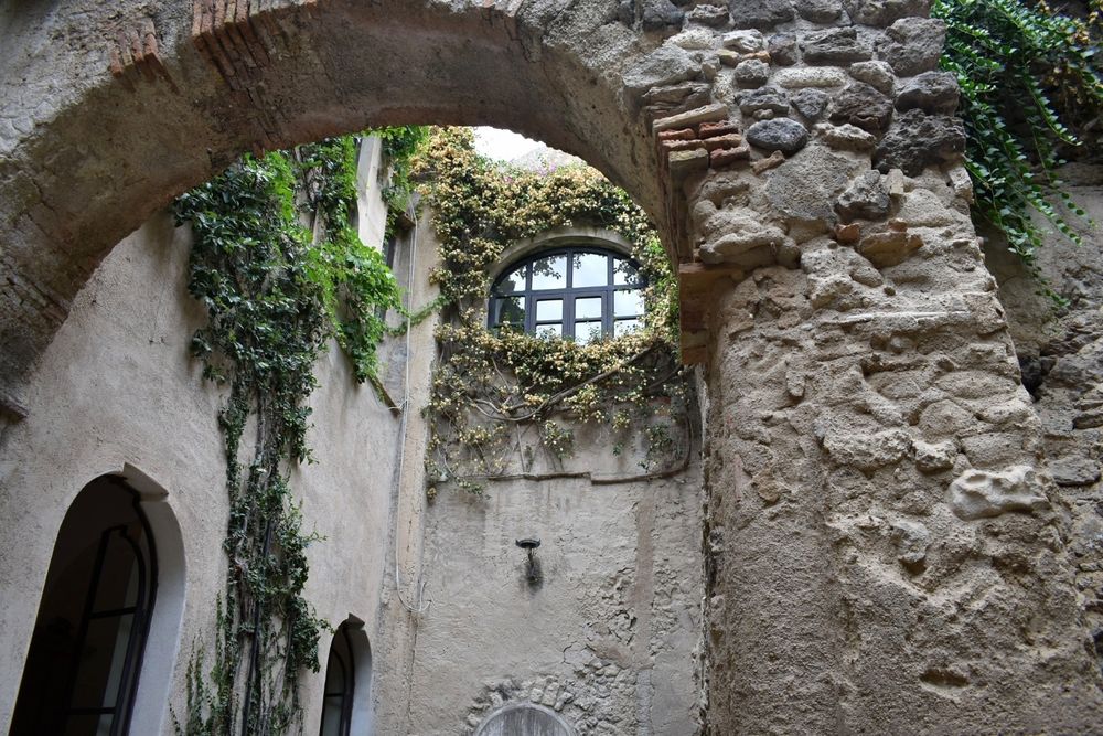 Circular window behind a stone arch in the Castello Aragonese in Ischia 