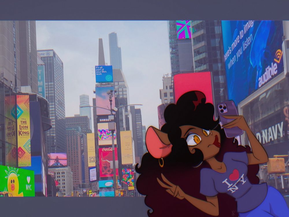 A pic of Margo the Shrew taking a selfie in Times Square. She’s wearing a purple “I love NY” t-shirt and giving duck-face and peace sign with her phone.