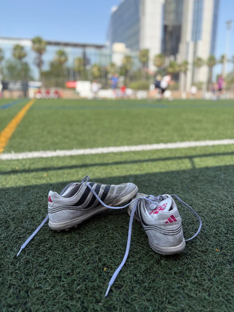 Boots next to a football field 