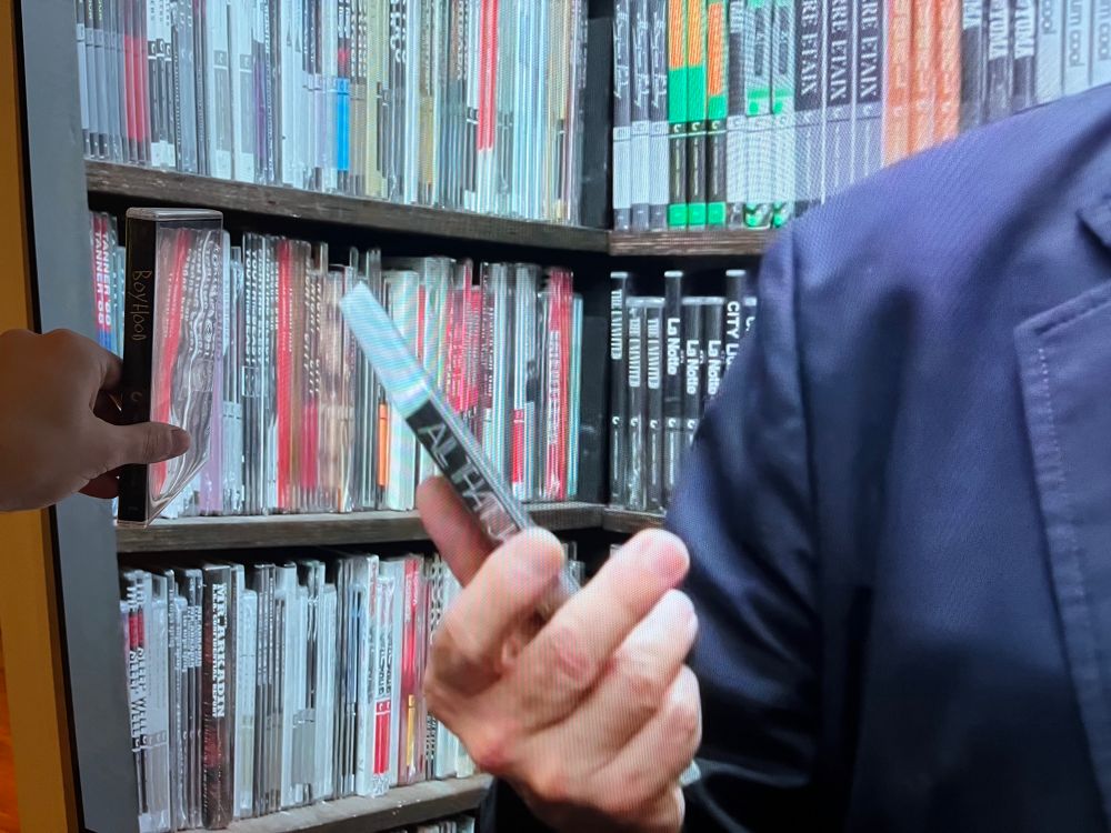 Close up holding a blu-ray up to screen, criterion closet discs are same size