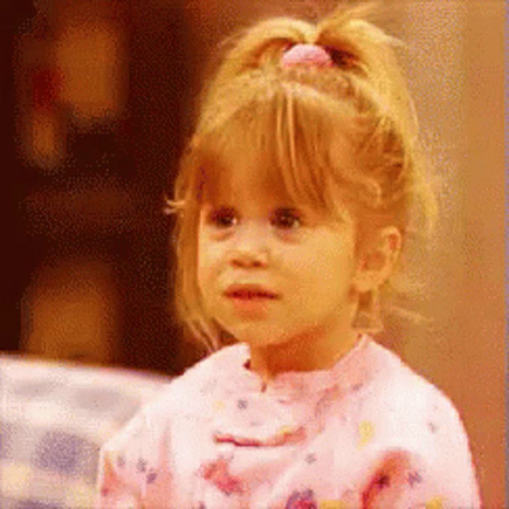 a little girl with a pink bow in her hair is wearing a pink shirt