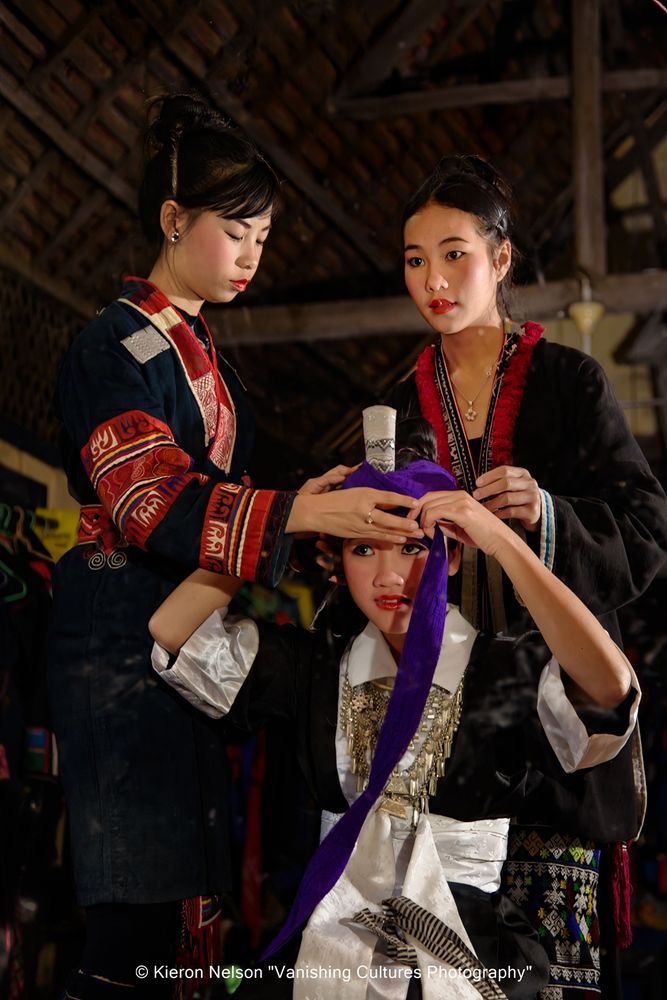  The Hmong turban reflected in a floor-length mirror. This distinctive headwear, particularly common among Hmong from Xieng Khuang Province, is a symbol of Hmong identity and cultural heritage, often passed down through generations. While traditionally hand-wrapped, modern adaptations include pre-made turban-style hats for convenience. 