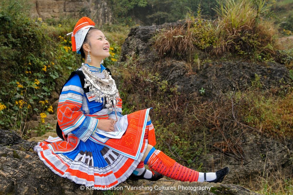 The rain did not dampen Yu Xiaoying from sharing a joke with my guide. Classified as a subgroup of the Miao. Very little is known about the Gejia apart from the fact that they specialize in batik, their colourful clothing is worn daily, as well as special attire for festivals. Due to their tradition of learning martial arts, or Wushu, their unique costumes resemble the style and design that ancient Chinese generals once wore. Their dyed handkerchiefs look like a general’s helmet; their outer coat like armor; and the silverware on their bodies take the forms of a sword, knife and hammer.