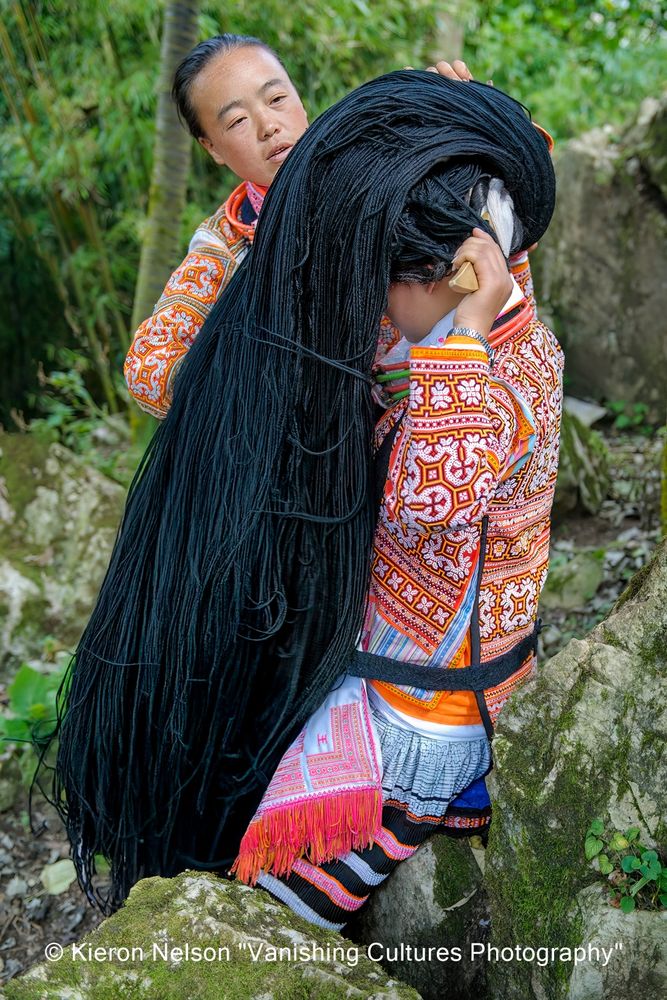 Guì Zhōu or Guìzhōu Shěng is a province located in the southwestern part of China. The Changjiao Miao people live in 12 villages near each other, situated in the mountains 2,000 meters above sea level, with a total population of 4,000. On a typical day, the women simply wrap their hair behind their heads around a sharp-ended wooden board. They wear the long horns only on holidays and during festivals, together with the decorative hair bun made of linen, wool, and small amounts of ancestral hair.
