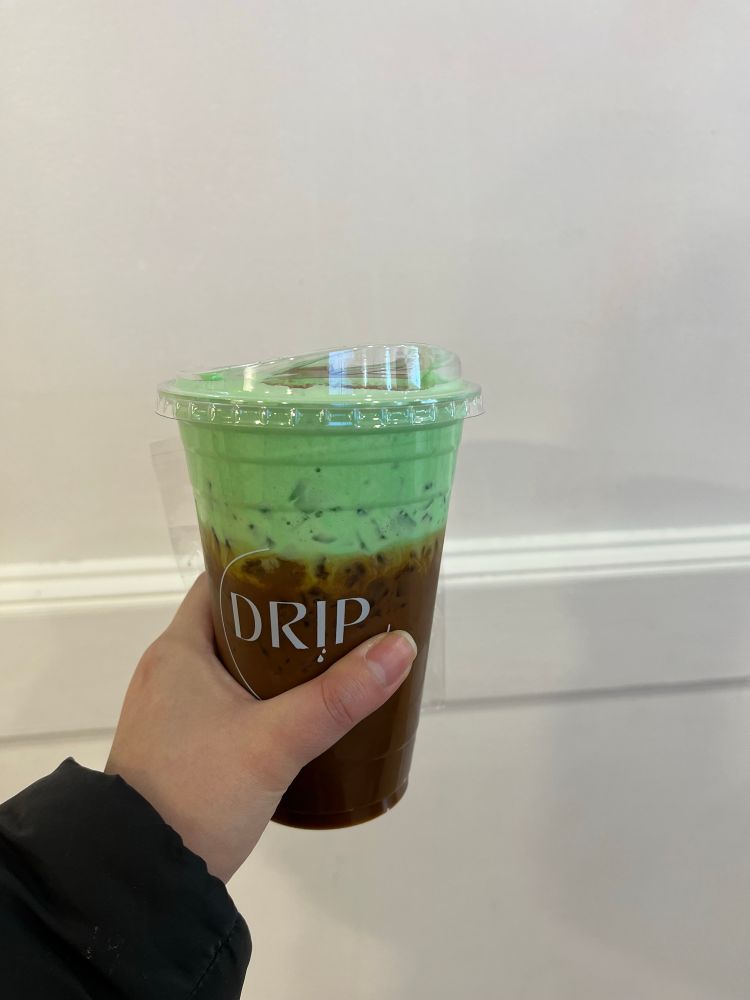 Iced Viet coffee with pandan foam at the top. Coffee is a plastic cup with “Drip”