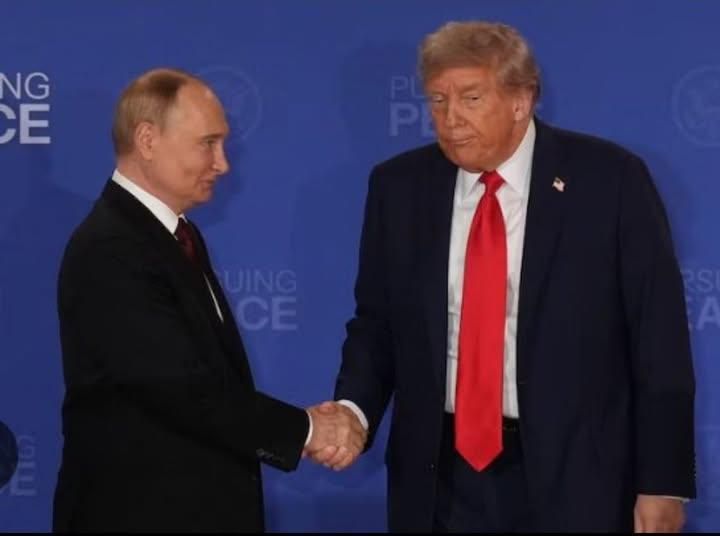 Vladimir Putin (left) shakes hands approvingly with Donald Trump (who looks old and defeated).