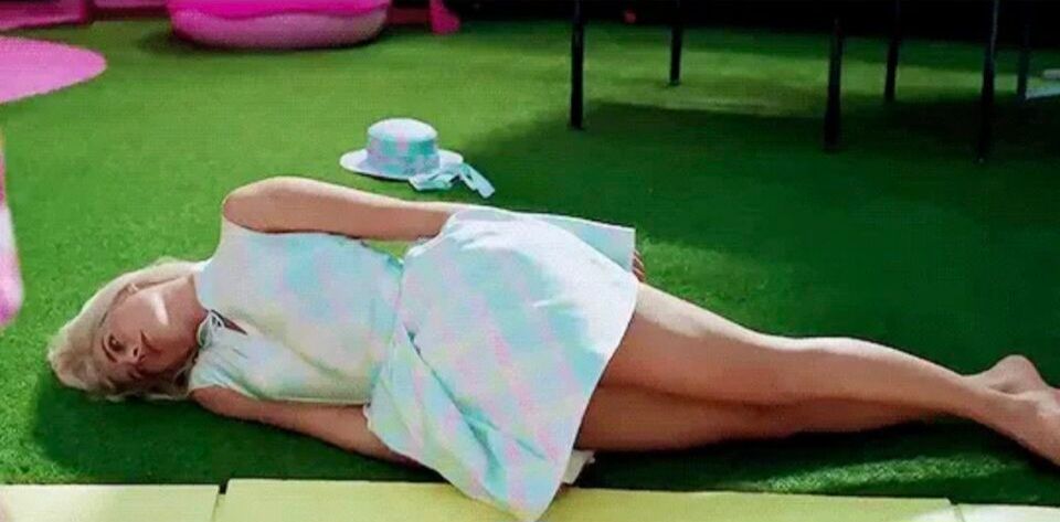 Barbie lying on the ground looking defeated 