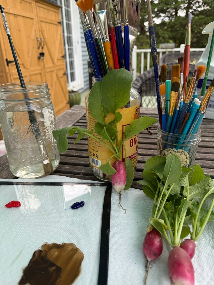 Photo of oil palette and radishes and paint brushes 