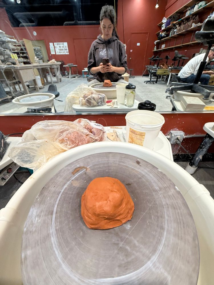 Photo of red clay on pottery wheel. 