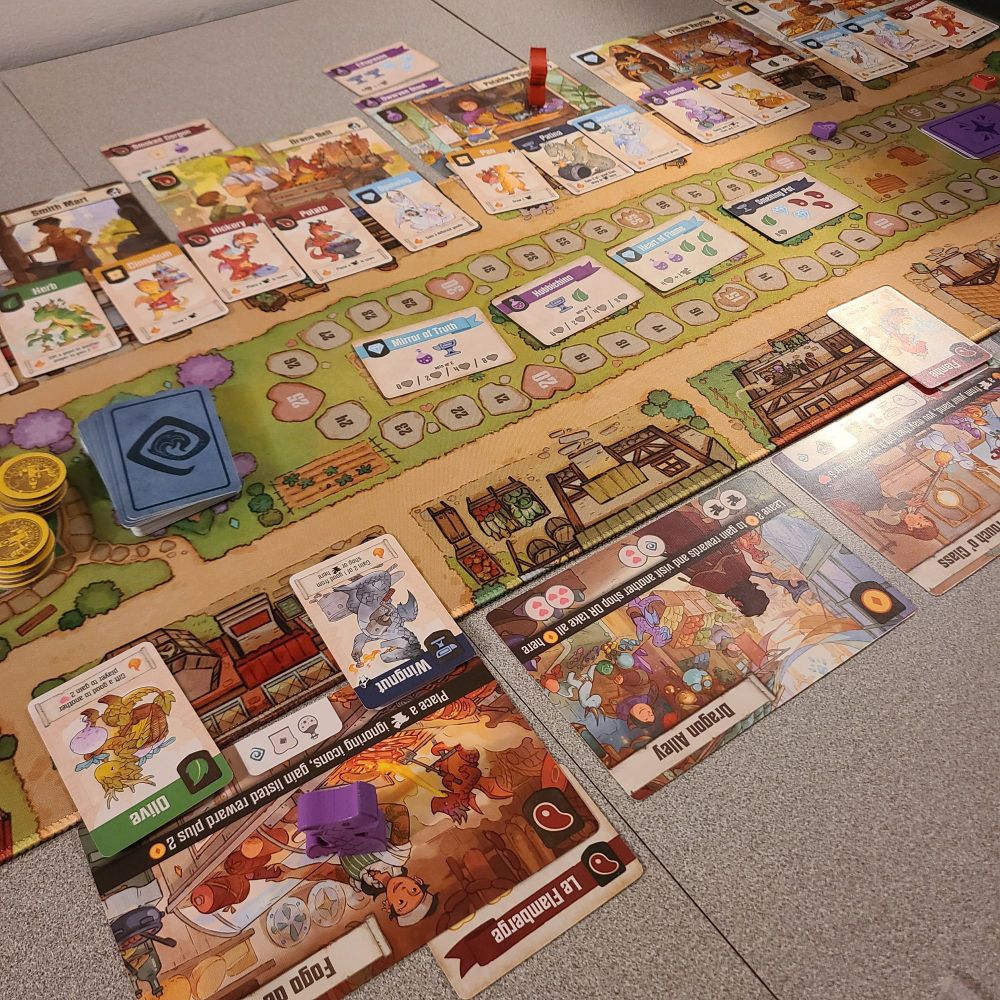 Flamecraft's board near the end of a typical game, with many different types of shop, worker dragon, and other cards laid out.