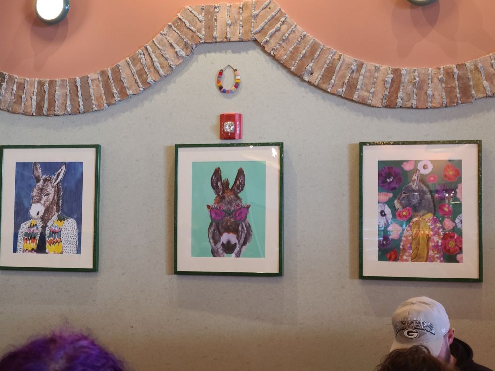 Pictures of donkeys in clothing conspicuously hanging on the wall