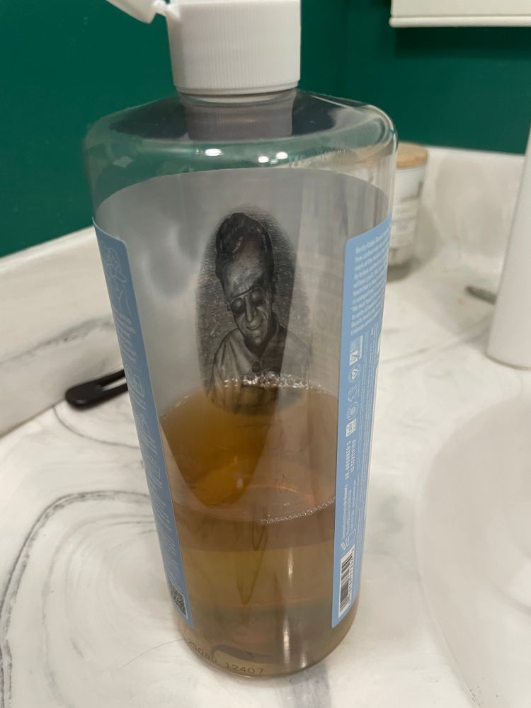 View of the inside of a Dr Bronners soap bottle with a picture of the founder staring back at you from the inside 