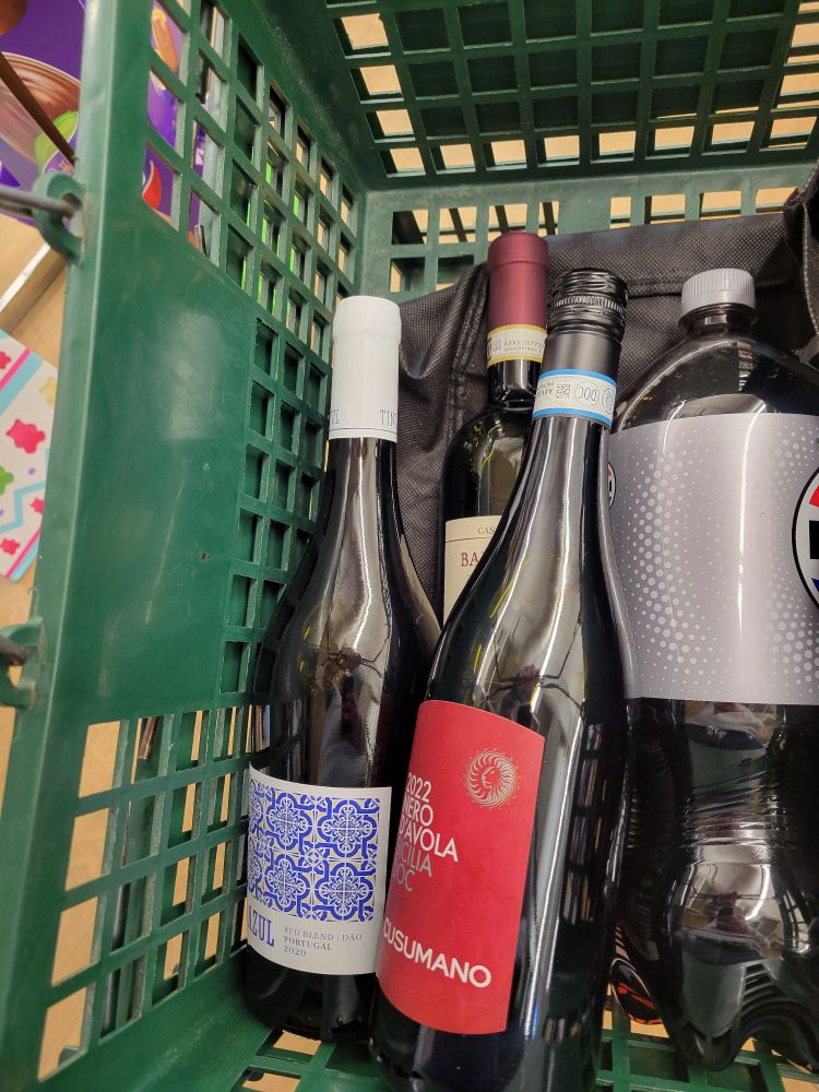 Three bottles of red wine and a 2-liter of diet Pepsi in a shopping basket