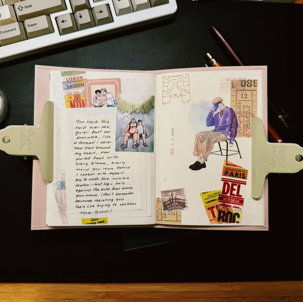 An open journal lies on a desk, held down with two beige clips labeled “PENCO.” The left page features a handwritten poem on a small card, surrounded by colorful travel-themed stickers and illustrations of two people sitting together. The poem reads:

“You have this hold over me,
quiet but unshakable, like a thread I never saw thread around my heart, now pulled taut with every glance, every word you leave behind.
I reason with myself, try to undo this invisible tether—but logic fails against the ache that hums your name. I don’t surrender because resisting you feels like trying to unlearn the Sun.”

The right page displays a large illustration of a person sitting on a chair with their face partially covered, wearing a purple sweater and beige pants. Surrounding the figure are vintage-style travel tickets and destination stickers from cities like Paris and New Delhi. In the background, a mechanical keyboard, a pen, and a notebook complete the cozy, creative workspace setup.
