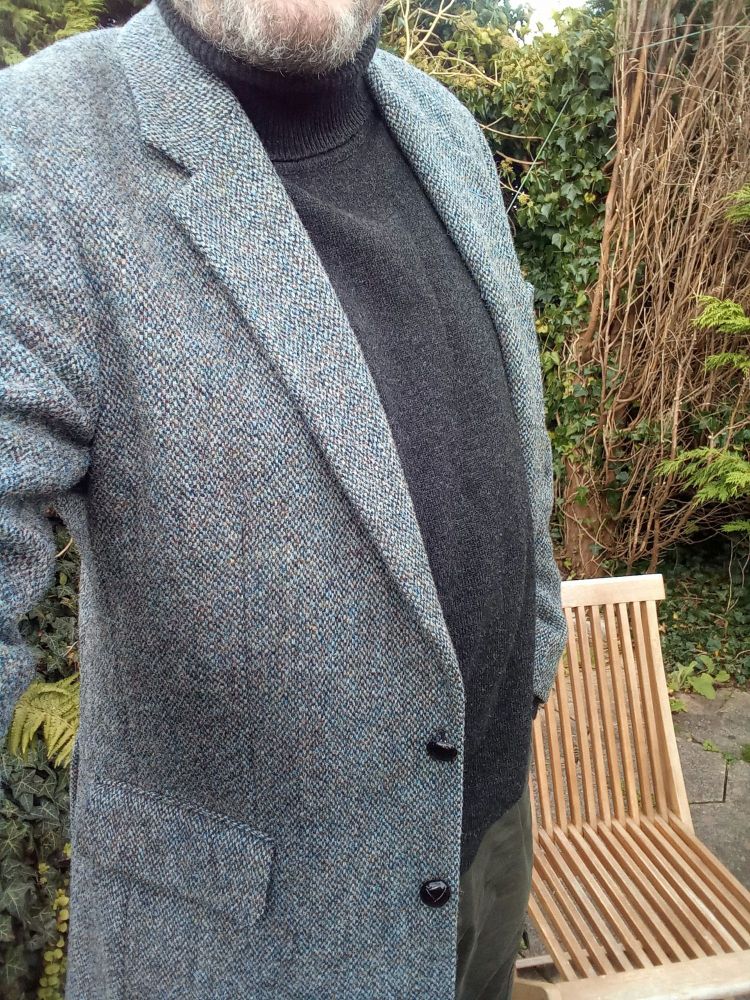 Bloke in a black roll neck jumper and bluey grey tweed sport coat. Thinks he looks a bit like Steve McQueen in Bullitt.......but he doesn't, he looks like an old man in a sports jacket.