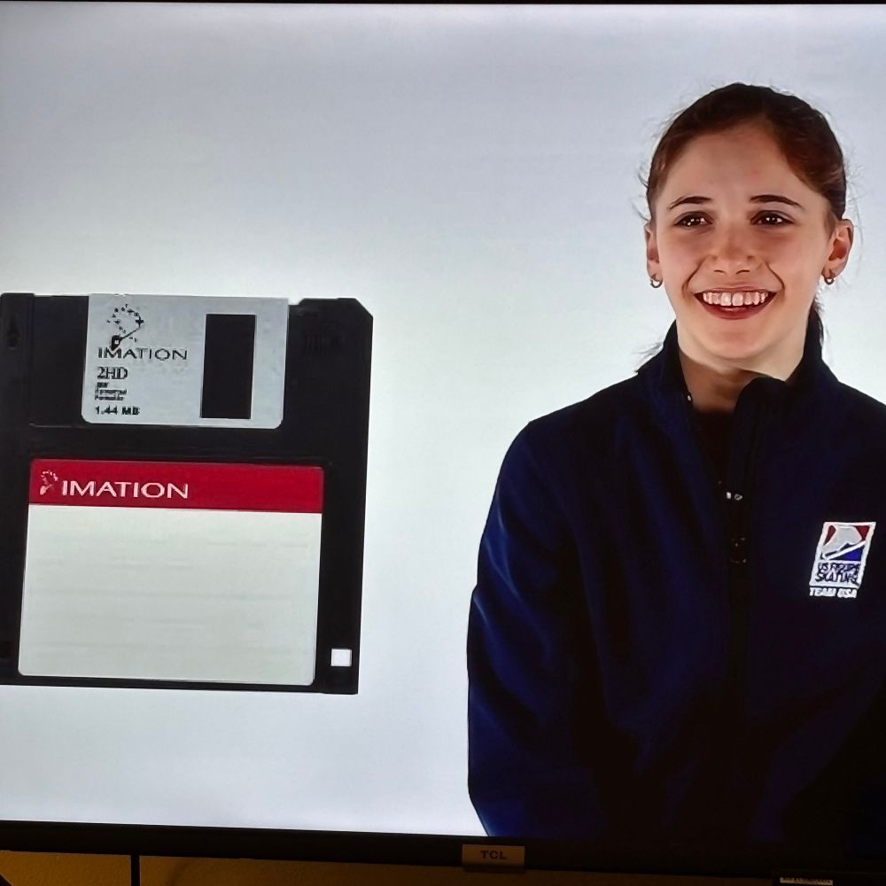 Figure Skater Isabeau Levito next to an image of a floppy disc (3.5 inch diskette from the 90s) while playing a “guess items from the 90s” game