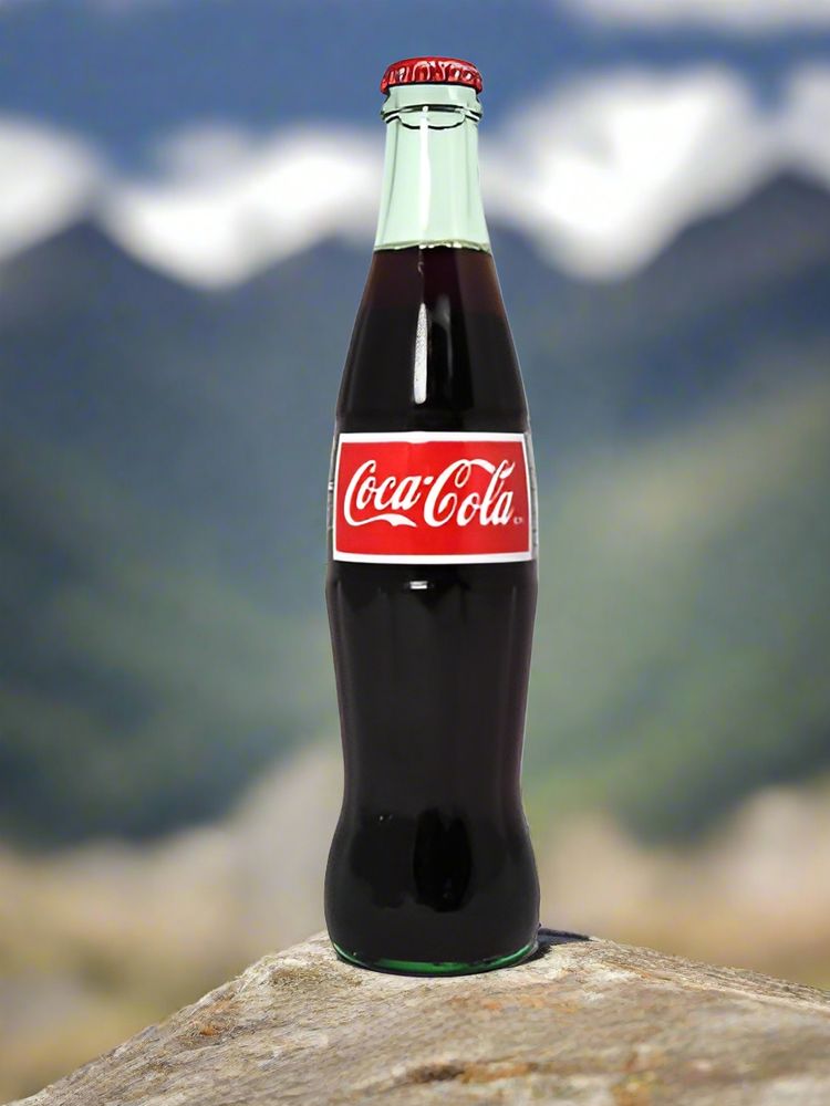 Image of a bottle of Mexican Coke with mountains in the background.