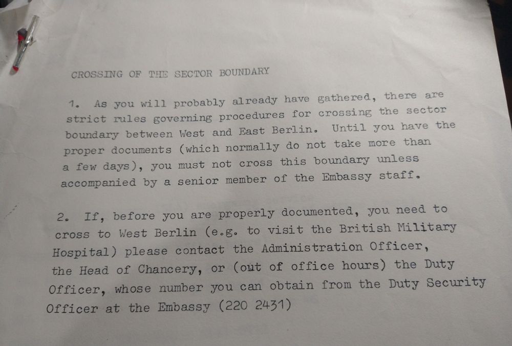 Colour photo of a typed set of instructions from 1978, explaining how to cross between East and West Berlin. Heading in capitals: "Crossing of the Sector Boundary". Paragraph 1 reads: "As you will probably already have gathered, there are strict rules governing procedures for crossing the sector boundary between West and East Berlin. Until you have the proper documents (which normally do not take more than a few days), you must not cross this boundary unless accompanied by a senior member of the Embassy staff." Paragraph 2 reads: "If, before you are properly documented, you need to cross to West Berlin (e.g. to visit the British Military Hospital) please contact the Administration Officer, the Head of Chancery, or (out of office hours) the Duty Officer, whose number you can obtain from the Duty Security Officer at the Embassy (220 2431)." 