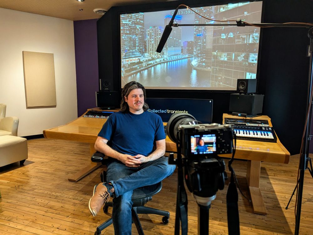 Stosh sitting in front of a camera at a sound studio trying to not look like a jabroni