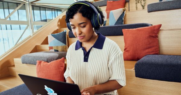 Developer sitting on wooden steps in an open workspace.