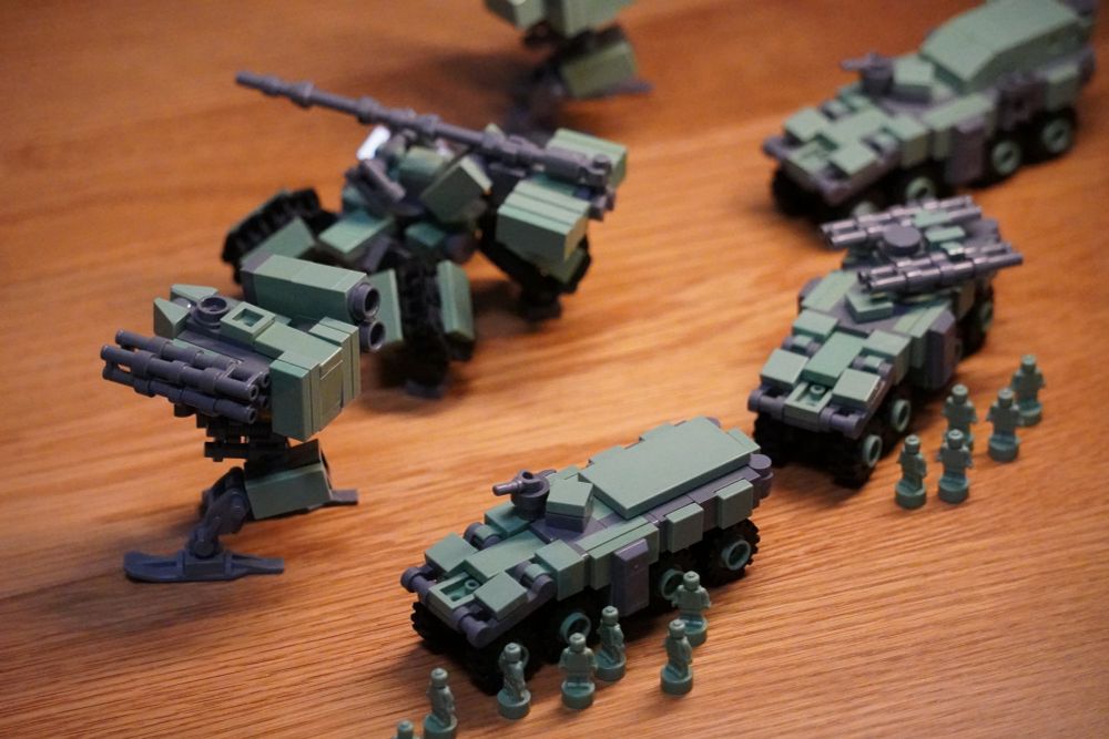 レゴブロックで制作された模型です。軍用ロボットの援護の元で装甲車が展開しています。