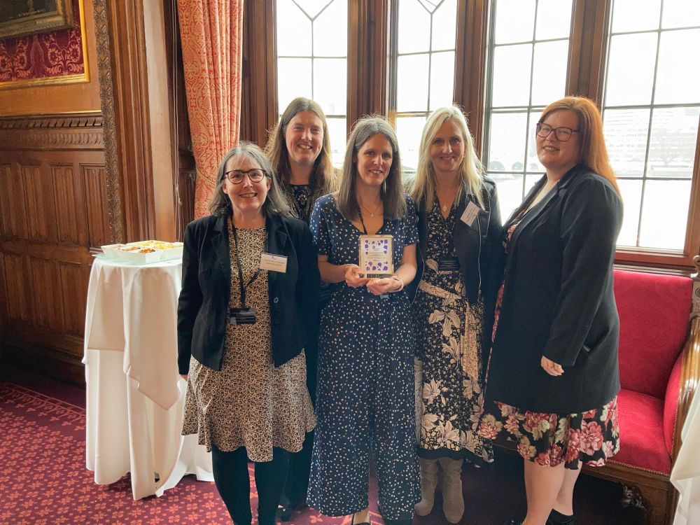 5 women in the Palace of Westminster holding an award