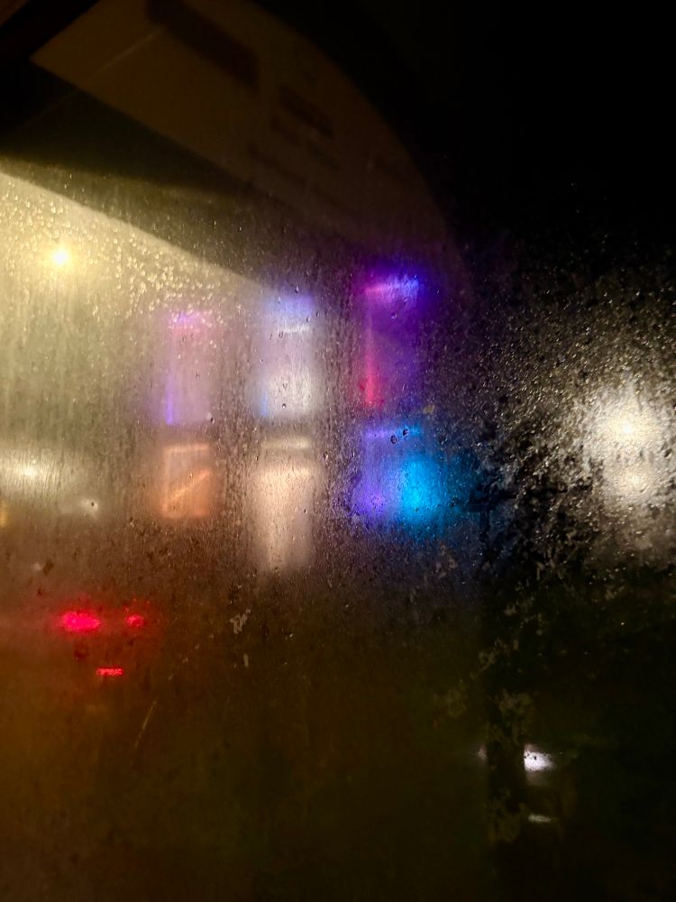 The building with colourful lights through a bus stop 
