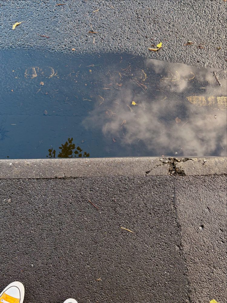 The sky reflected in a puddle 
