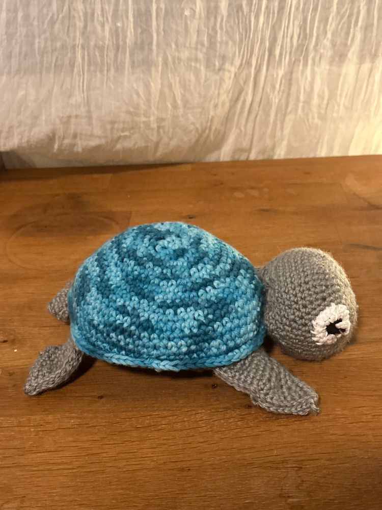 Bilde av en heklet, grå skilpadde med blåmelert «skall».