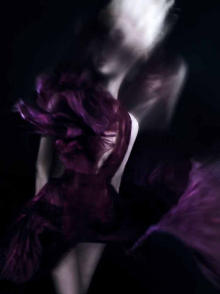 Distorted fashion photography featuring a pale woman in a maroon gown micro pleated in silk organza on black background 
