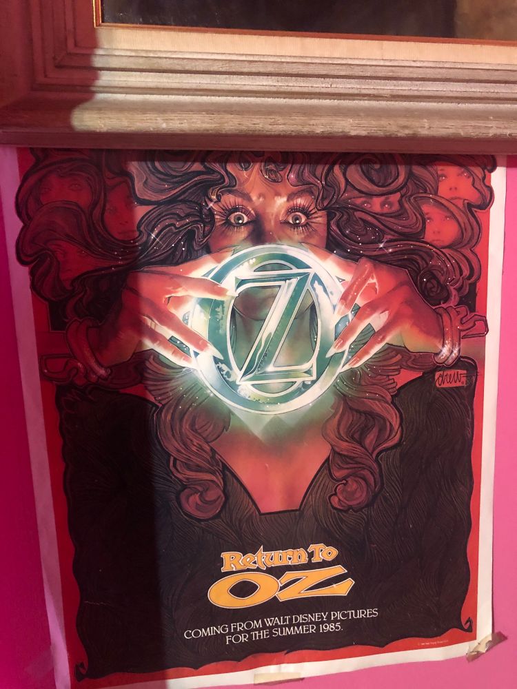 Return To Oz movie poster with the bottom bit of frame from a painting I hung slightly over it due to a lack of wall space (the bright pink is the wall)