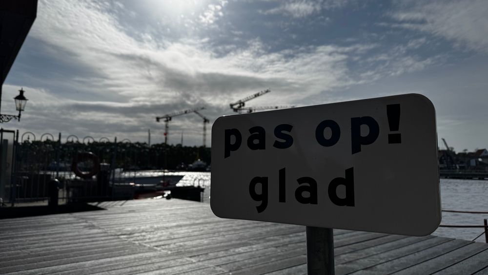a sign that says “pas op! glad”