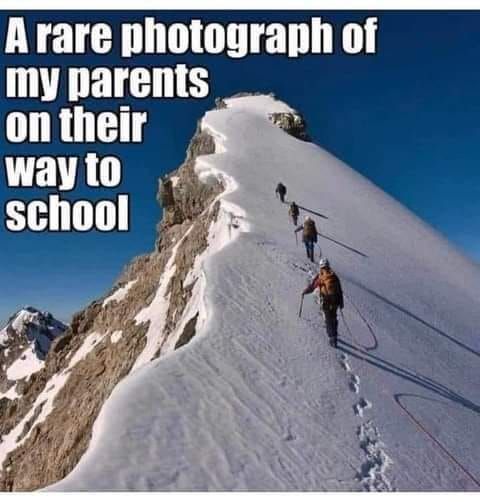 a rare photo of my parents on their way to school -- photo of climbers ascending a steep snowy mountain - maybe Everest