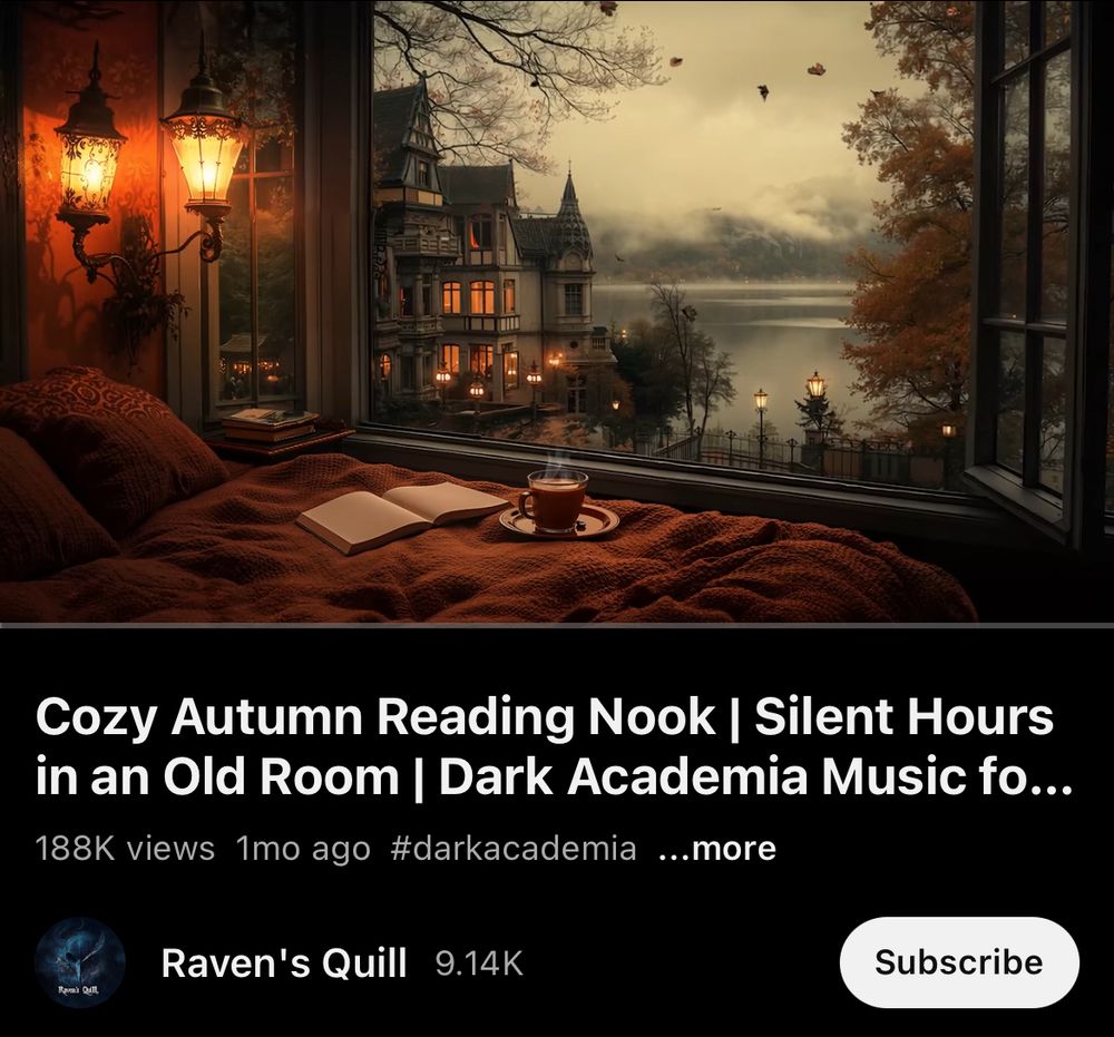 A cozy autumn reading nook with a warm orange blanket, an open book, and a steaming cup of tea on a saucer sits by a large window. Outside, a grand old building with glowing lights overlooks a misty lake surrounded by autumn trees with golden leaves. The scene is softly lit by ornate wall lamps, creating a dark academia atmosphere. Text on the image shows a YouTube video titled “Cozy Autumn Reading Nook | Silent Hours in an Old Room | Dark Academia Music,” posted by Raven’s Quill.