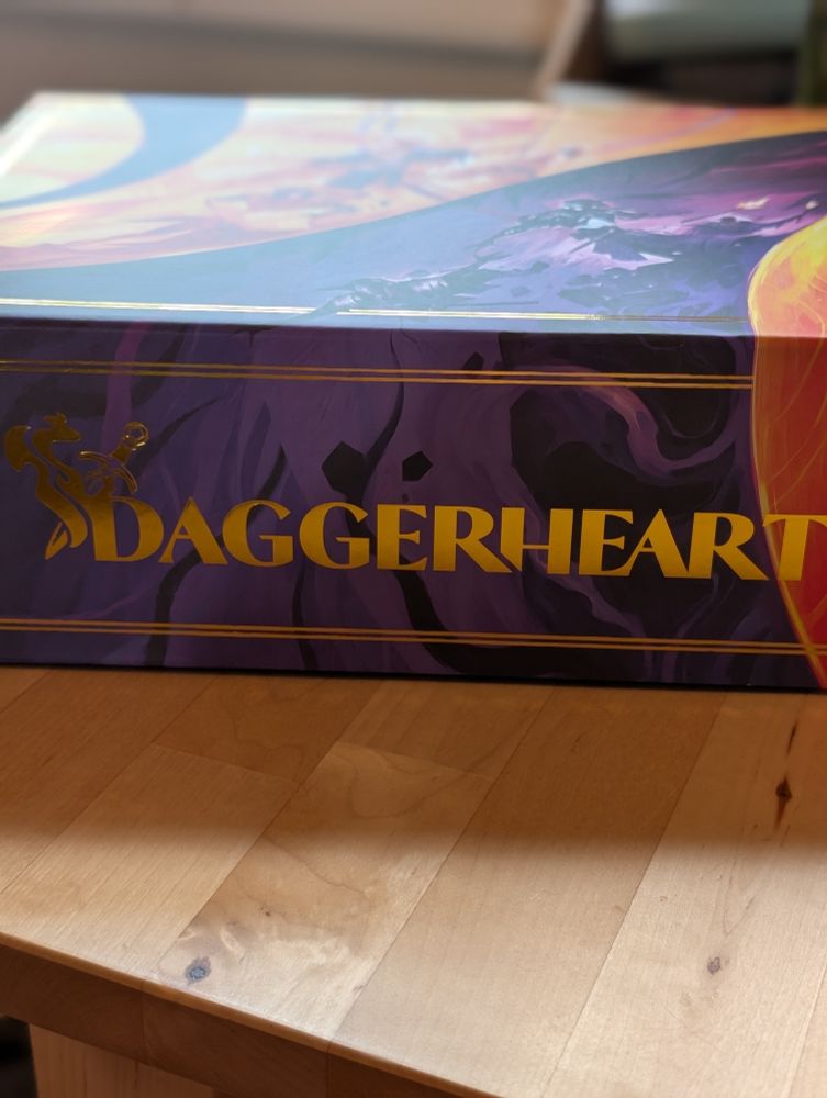 Purple and orange box with "Daggerheart" logo written in gold
