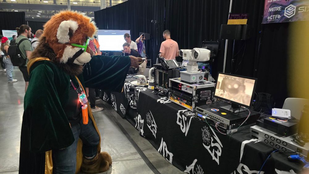 Burbley the Red Panda Wizard points at his own far infrared image at a technology demomstration display