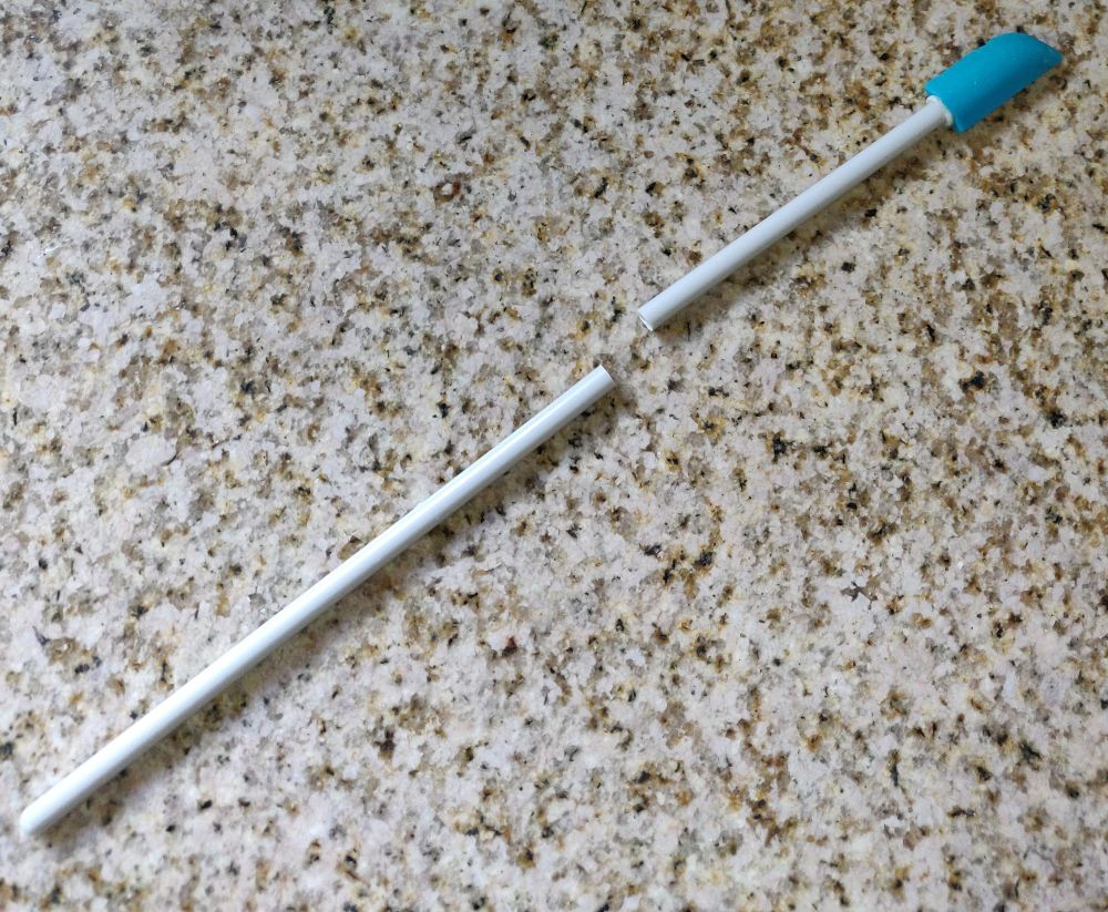 a very long-handled skinny spatula laying on a countertop; the handle has broken