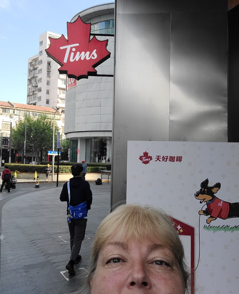 My forehead in front of a Shanghai Tim's (Tim Horton's) sign shaped like a maple leaf.