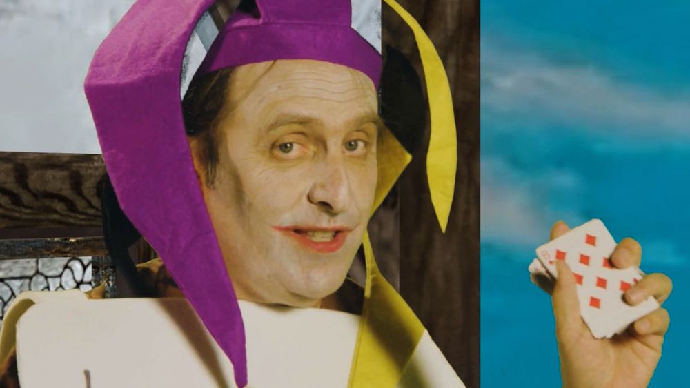 Gregg Turkington as The Joker holding up a deck of cards, from the film "Deck of Cards" (2022).